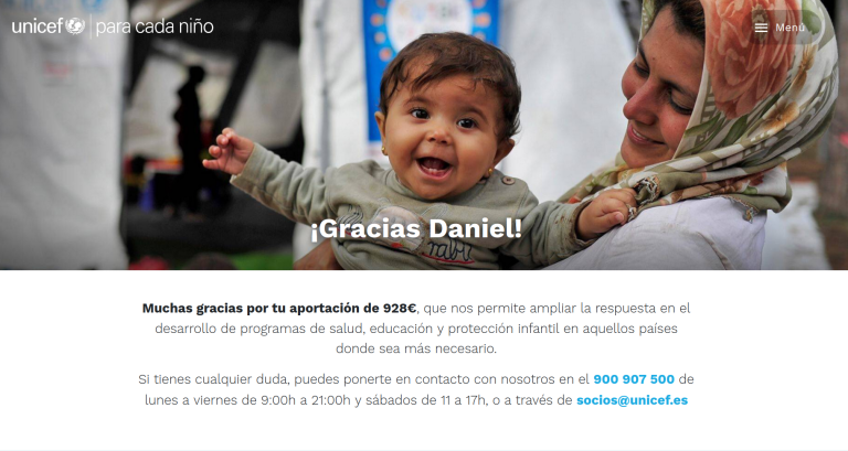 Niña sonriente sostenida por una mujer en campaña de UNICEF agradeciendo donantes 2022.